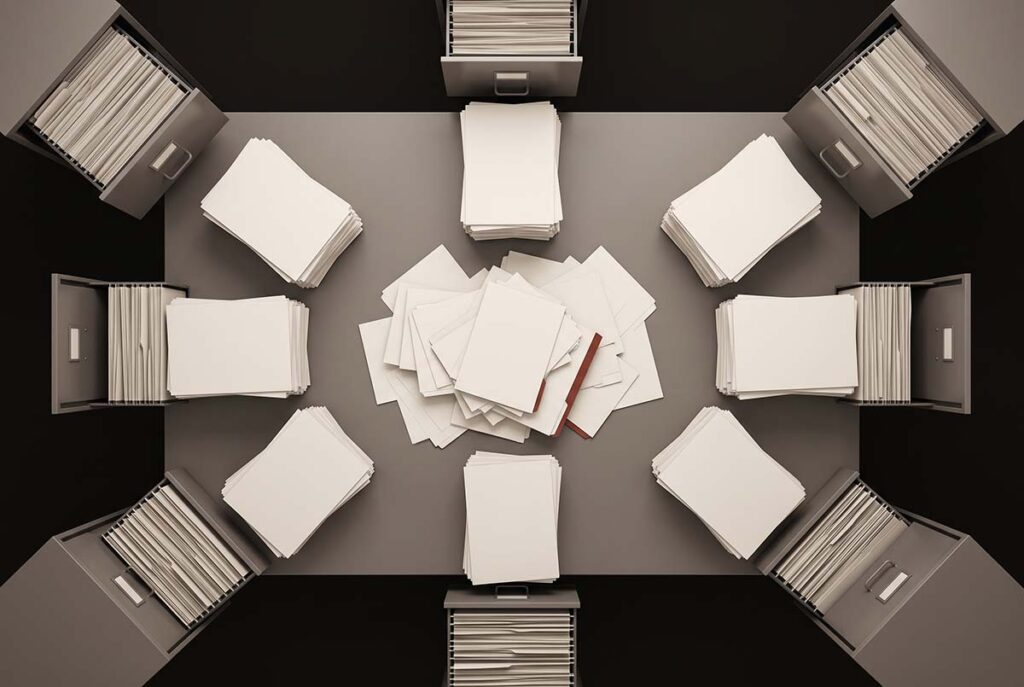 An overhead filing table with scattered blank documents that do not fit into any open drawer, representing unresolved professional identity.
