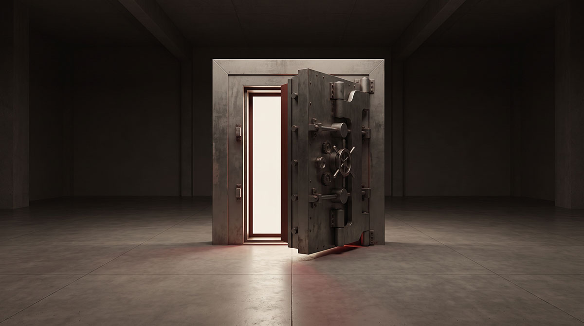 A freestanding steel vault door stands slightly open in a dark institutional space with warm light spilling through the gap.