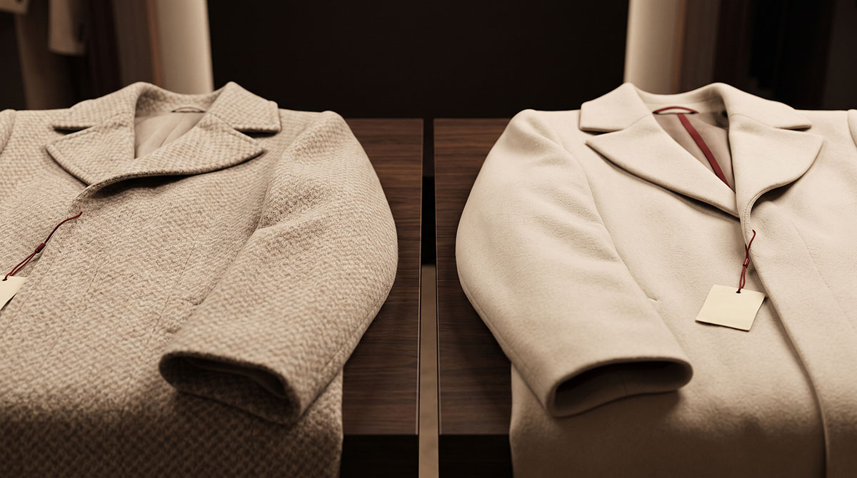 Two unbranded cashmere coats under warm light showing quiet luxury logo erasure as a pricing signal